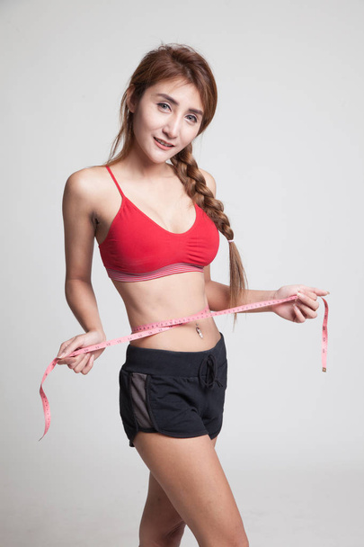 Beautiful Asian healthy girl measuring her waist. - Fotoğraf, Görsel