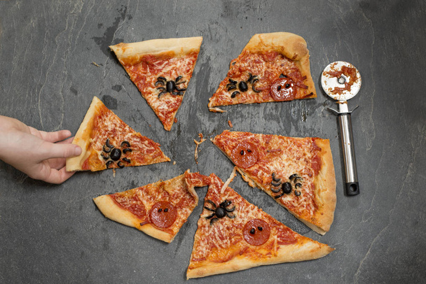 Vesz egy szelet Halloween Pizza keze - Fotó, kép