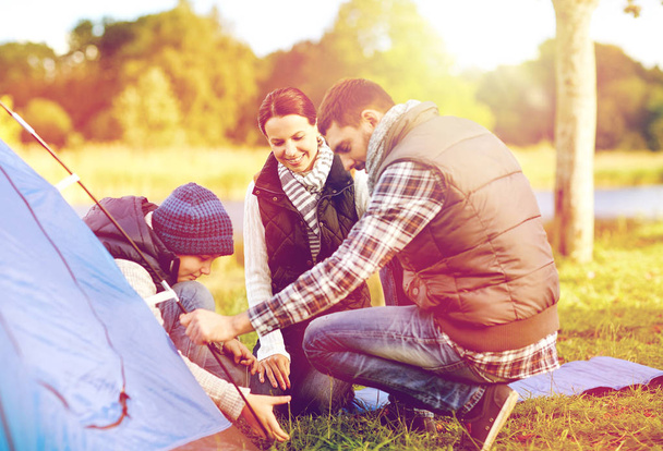 happy family setting up tent outdoors - Foto, Imagen