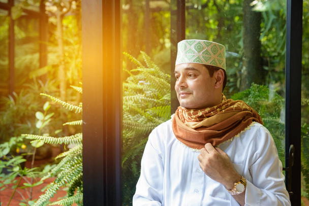Porträt eines arabischen muslimischen Mannes, der Hijab in der Hand hält - Foto, Bild