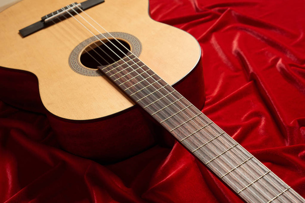 акустична гітара на червоній оксамитовій тканині, вид на об'єкт
 - Фото, зображення