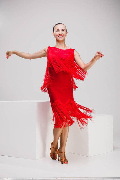 girl in red dress dancing in white studio - Foto, Imagen