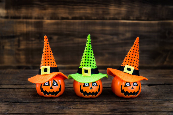 Tarjeta de Halloween con pequeñas cabezas de calabaza en sombreros de bruja
 - Foto, imagen