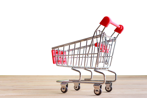   Shopping Cart isolated on wood and white background. - 写真・画像