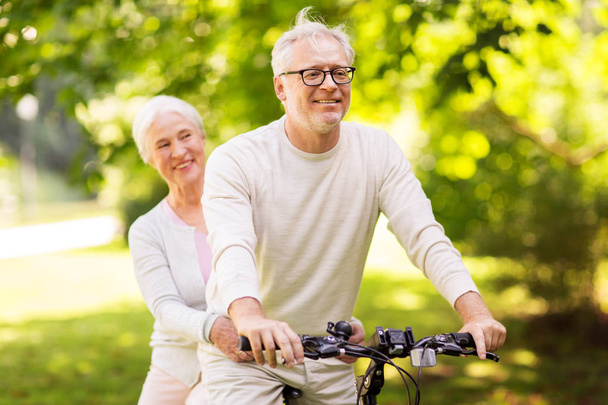 szczęśliwa para starszy jazdy na rowerze w parku - Zdjęcie, obraz