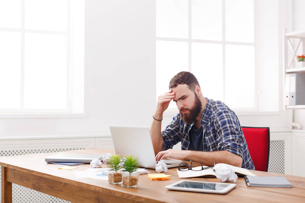 Zmęczony, przepracowaniem biznesmen z laptopa w nowoczesnym biurze biały - Zdjęcie, obraz