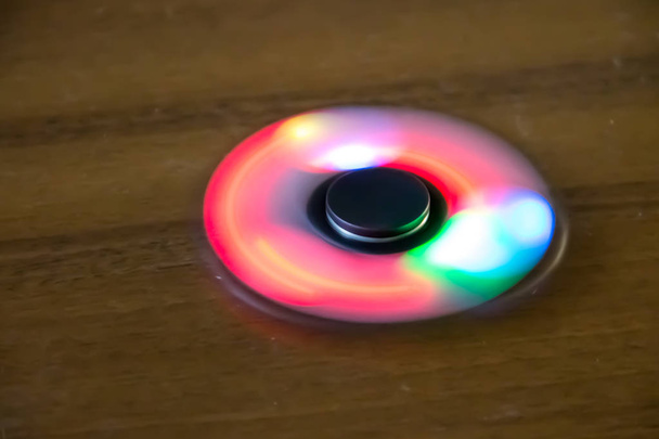 Fidget spinner jouet avec lumière led sur la table
 - Photo, image