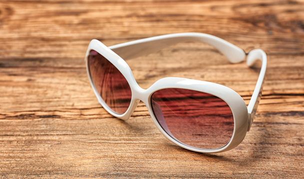 Beautiful sunglasses on wooden - Фото, изображение