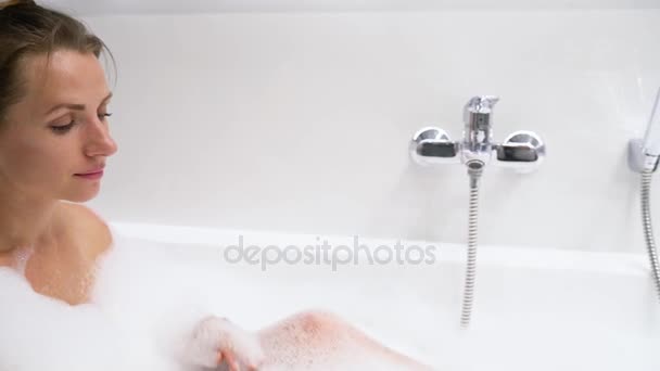 Woman relaxes and takes a bath with foam - Filmagem, Vídeo