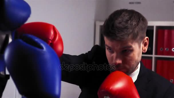 zwei aggressive Konkurrenten in Handschuhen boxen und kämpfen im Büroraum - Filmmaterial, Video