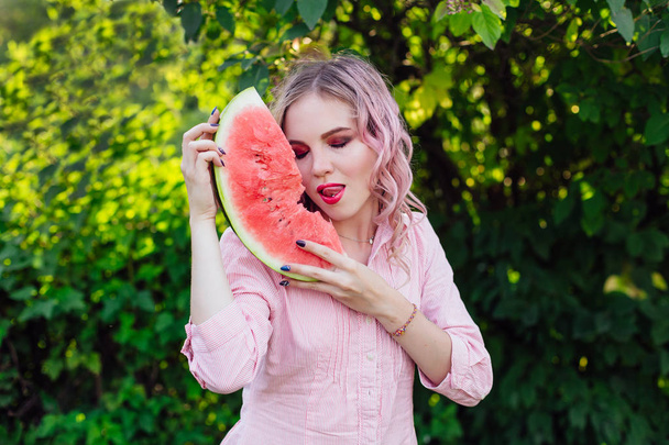 Beautiful young woman with pink hair enjoying watermelon - Valokuva, kuva
