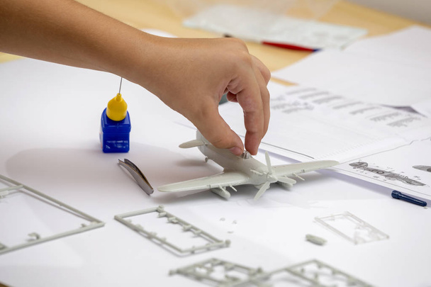 Boy hand assembling plastic model kit of ww2 aircraft - Photo, image