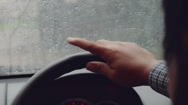 Мужские руки на руле машины сфокусированы. Пальцы стучат в сильный дождь
. - Кадры, видео