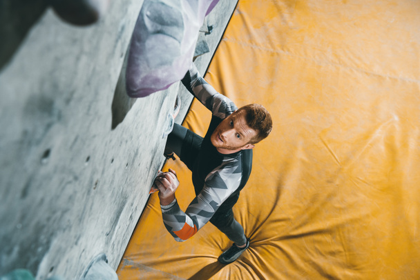 Man climbing wall with grips - Photo, Image