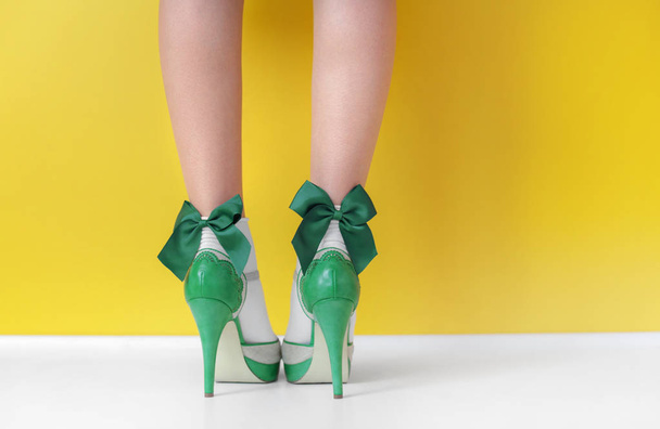 Female legs in green high heel shoes and socks  - Fotó, kép