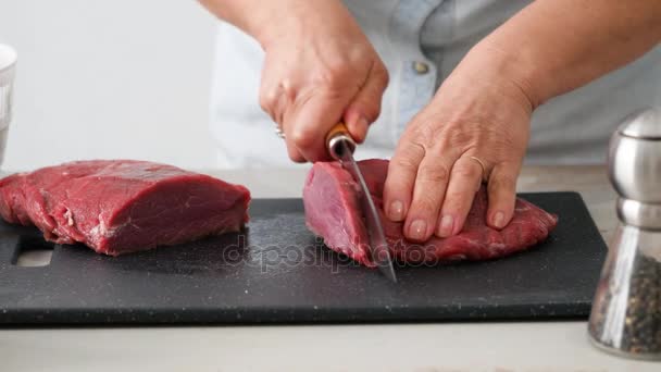 cutting raw beef on a cutting board closeup - Footage, Video