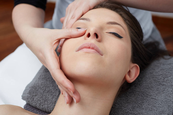 Female Enjoying Relaxing face Massage In Cosmetology Spa Center - Foto, afbeelding