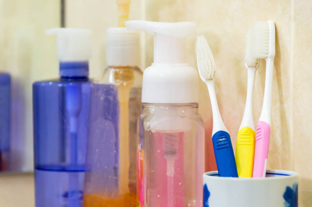 Οδοντόβουρτσες με μπάνιο οριστεί, αεροζόλ και σαπούνι στο σκαμνί. - Φωτογραφία, εικόνα