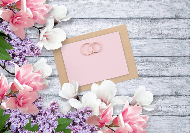 Magnolia, lilacs, bridal rings and paper card for wedding - Fotoğraf, Görsel