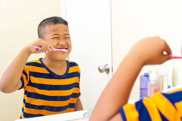 Азіатський хлопчик чистити зуби у ванній кімнаті з зубна щітка здорового Лі - Фото, зображення