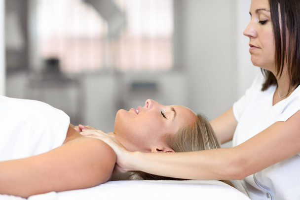 Young woman receiving a head massage in a spa center. - Φωτογραφία, εικόνα
