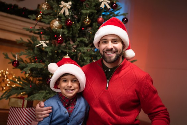 père et fils en chapeaux de Père Noël
 - Photo, image