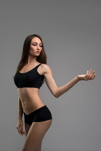 Slim brunette in black shorts and top cropped view - Zdjęcie, obraz