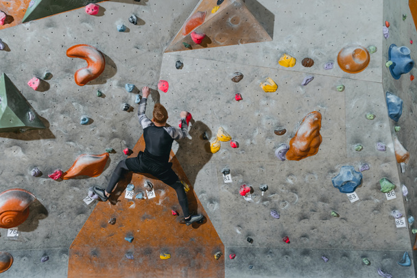 Man climbing wall with grips - Фото, изображение