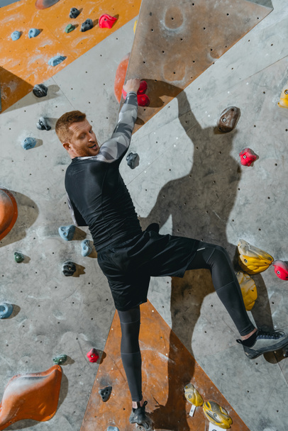 Man climbing wall with grips - Photo, Image