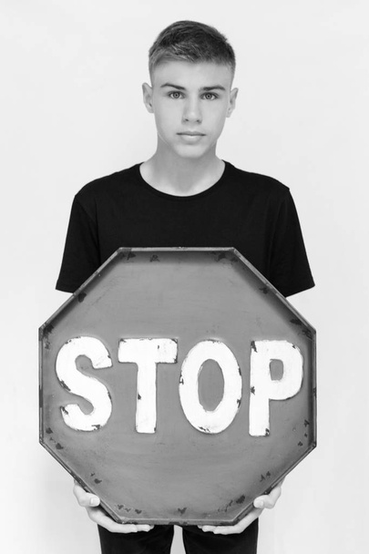 ein Teenager mit einem Stoppsymbol, Stopp, auf weißem Hintergrund in einem  - Foto, Bild