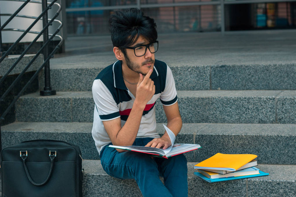 cute brooding student sits with books - Φωτογραφία, εικόνα