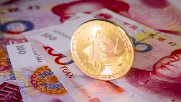 Financial concept with golden Bitcoin over chinese yuan bill - Footage, Video