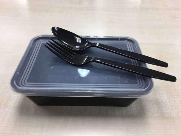 スプーンとフォークで黒いプラスチック製の食品容器 - 写真・画像