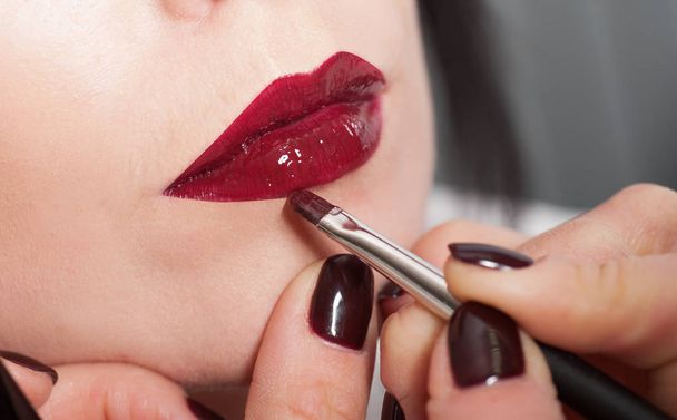 maquillage artiste peint une fille lèvres avec rouge à lèvres
 - Photo, image