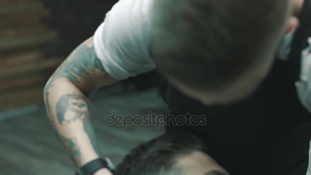 Barber shaves the beard of the client. - Imágenes, Vídeo