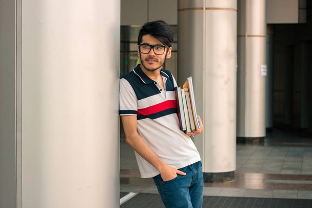 cute guy in a t-shirt stands on the street and keeps on hand book - Photo, image