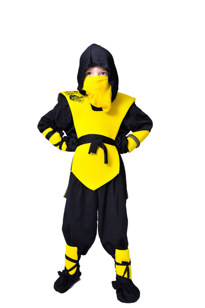 Le garçon de sept ans en costume ninja noir et jaune avec une ho
 - Photo, image