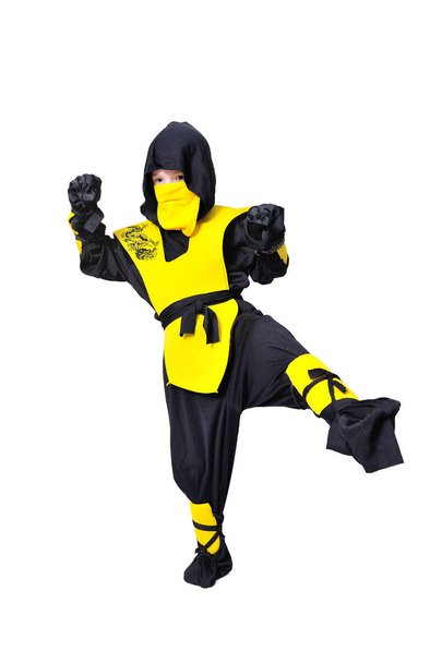 der siebenjährige Junge im schwarz-gelben Ninja-Anzug mit einem - Foto, Bild