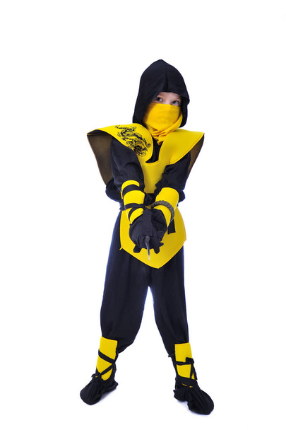 De zeven-jaar oude jongen in zwarte en gele ninja pak met een ho - Foto, afbeelding