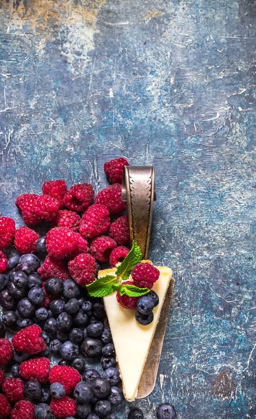 Cheesecake with berries on blue slate background.  - Photo, Image
