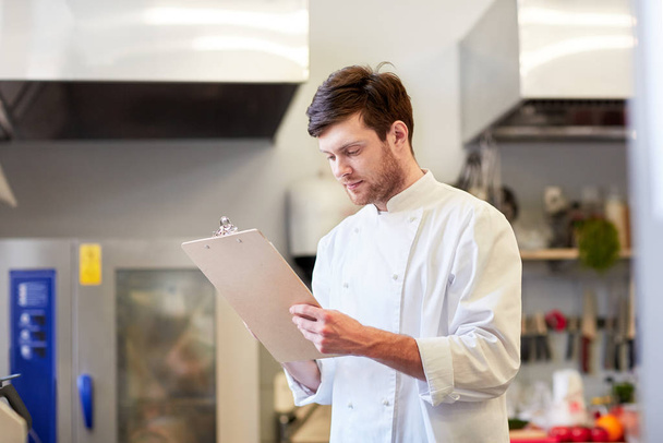 chef with clipboard doing inventory at restaurant - Foto, Bild