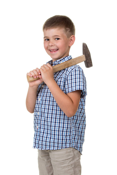 Happy kid in blue checkered shirt holding hammer and smiling against white background - 写真・画像