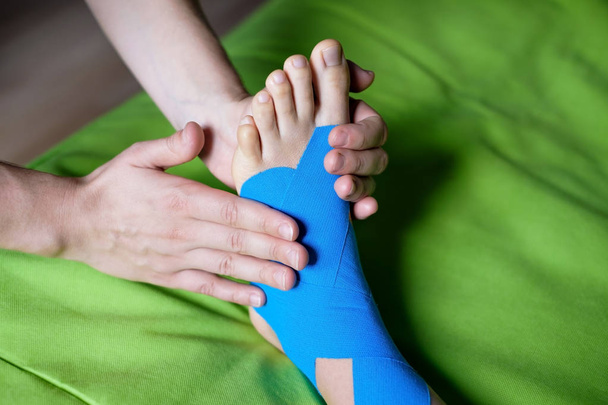 Doctor taping woman injury leg. - Φωτογραφία, εικόνα