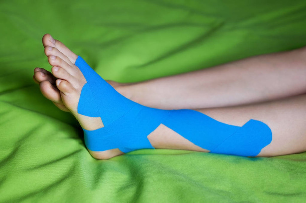 Terapeutyczne taśma niebieski elastyczna stosowane do lewej nogi pacjentów. - Zdjęcie, obraz