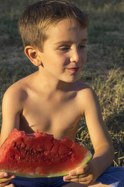 Młody chłopiec kaukaski z jego eater pół arbuza - Zdjęcie, obraz