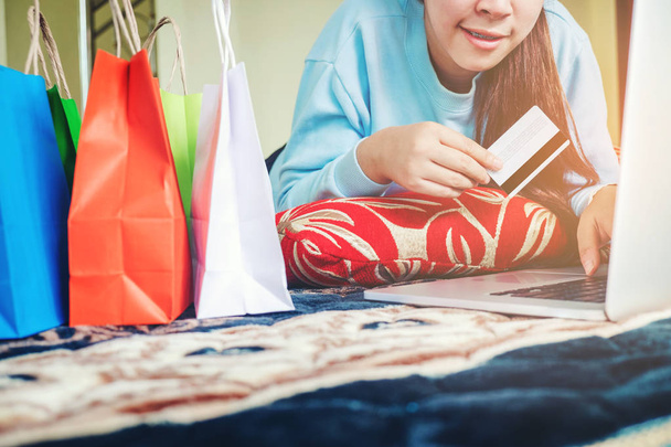 Woman shopping online using laptop with credit card enjoying in  - Foto, Imagen