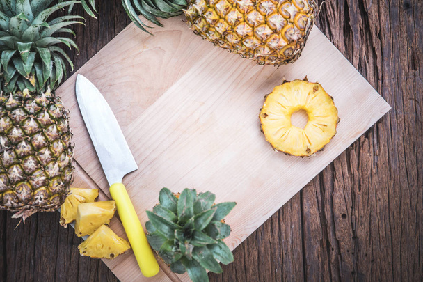 Ananasscheiben auf einem Schneidebrett mit einem Messer - Foto, Bild
