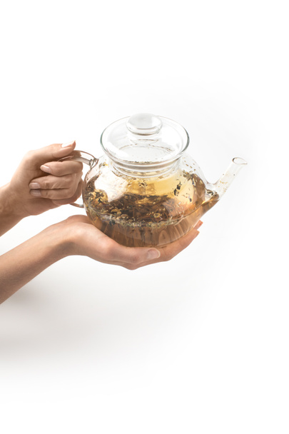 Glas-Teekanne mit Kräutertee in den Händen - Foto, Bild