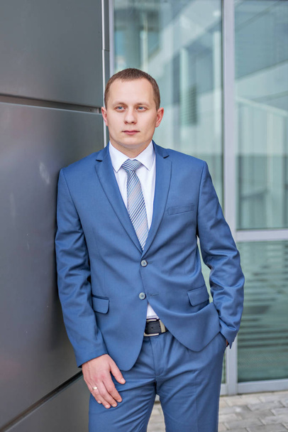 portrait of a young serious smiling businessman in grey blue suit - Фото, зображення