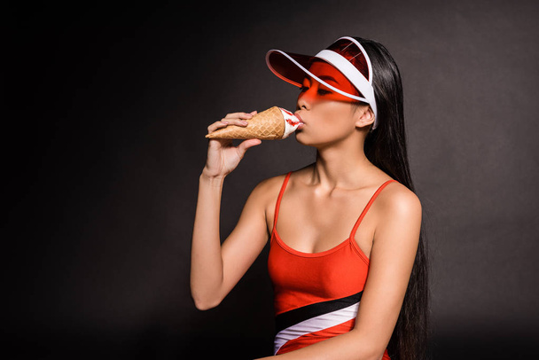 donna in costume da bagno e visiera mangiare gelato
 - Foto, immagini